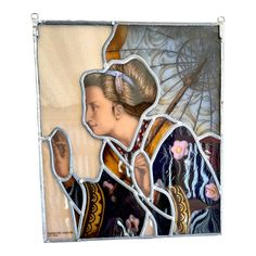 a woman holding an umbrella in front of a stained glass wall hanging on a wall