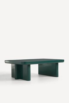 a green table sitting on top of a white floor