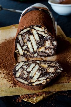 there is a chocolate roll with white stripes on the top and bottom, cut in half