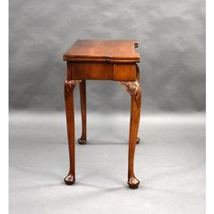 a small wooden table with one drawer on the top and two legs at the bottom