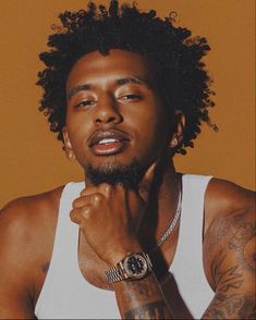 a close up of a person with a watch on his wrist and wearing a white tank top