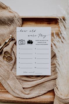 a wooden box with a note and some scissors on it next to a feathery plant