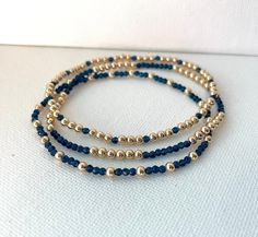 These beautiful bracelets are made of 14k gold filled beads and navy blue beads which come on a stretch cord to easily put on and take off. They're elegant, perfect for every occasion and make great gifts!  Patterns may vary slightly depending on wrist size. Gold filled beads size: 3MM Navy blue beads size: 2.5MM *FREE SHIPPING* Diy Elegant Bracelet, Navy And Gold Jewelry, Blue And Silver Beaded Bracelets, Blue And Gold Beaded Bracelets, Navy Blue And Gold Jewelry, Navy Blue Beaded Bracelet, Blue Beaded Bracelets For Men, Blue And Gold Bracelets, Navy Blue Bracelet