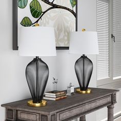 two lamps sitting on top of a wooden table