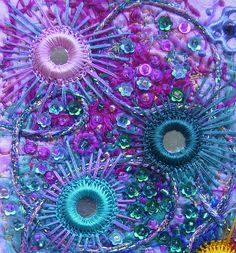 an abstract painting with beads and flowers in the middle on a purple background that looks like something out of space