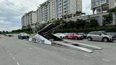 several cars parked in a parking lot with an upside down sign on the side of the road