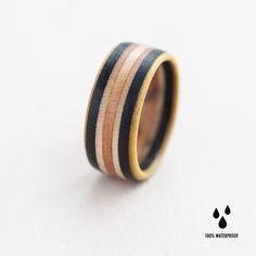 a wooden ring with black, white and gold stripes on the inside is shown against a white background