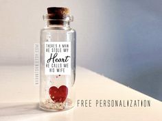 a bottle filled with lots of tiny hearts on top of a white counter next to a sign that says thank you from the bottom of my bottle