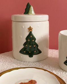 a white plate topped with a piece of cake next to a christmas tree cookie jar