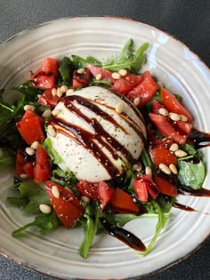 a white plate topped with salad covered in dressing