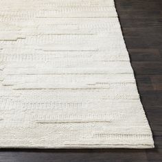 a white rug on top of a wooden floor