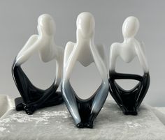 three black and white figurines sitting on top of each other