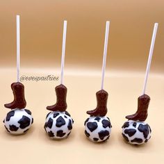 four chocolate candies decorated with black and white polka dots, cowboy boots on them