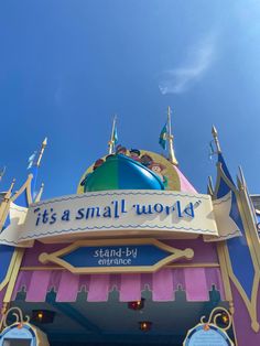 there is a sign that says it's a small world at the entrance to an amusement park