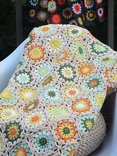 a crocheted bag sitting on top of a white chair next to a pot holder