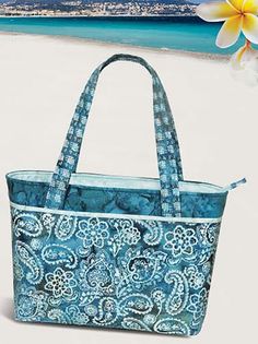 a blue and white tote bag sitting on top of a beach