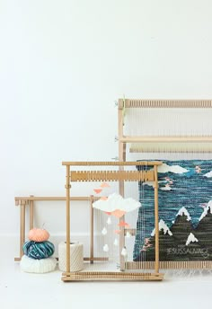 two weaving looms are sitting next to each other on the floor in front of a white wall