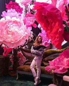 a woman sitting in a boat surrounded by pink flowers