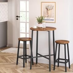 two stools and a table in a room with white walls, hardwood floors and wooden flooring