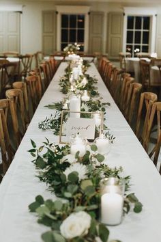 the long table is set with candles and greenery for an elegant dinner or reception