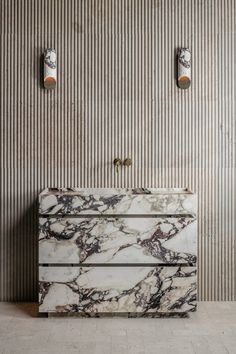 a marble counter top in front of a wall with two light switch plates on it