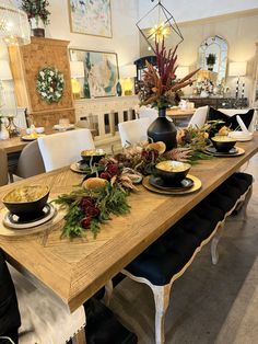 a dining room table set for christmas with plates and bowls on it, surrounded by holiday decorations