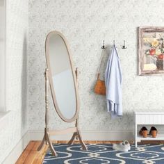 a bathroom with a blue rug, mirror and coat rack on the wall next to it