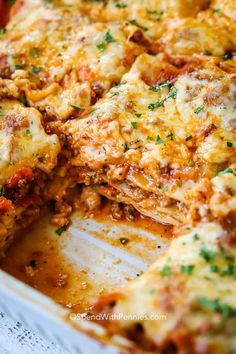 a casserole dish with meat and cheese on it, cut in half to show the layers