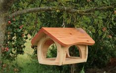 a wooden bird house hanging from a tree