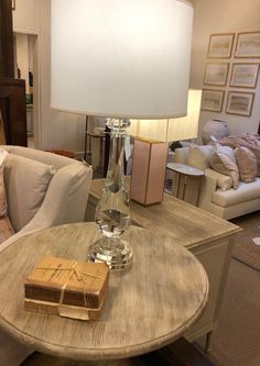 a glass bottle sitting on top of a wooden table next to a white couch in a living room