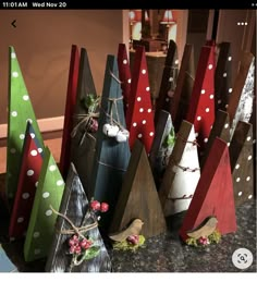 several wooden christmas trees are lined up on the counter