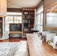 a living room filled with furniture and bookshelves next to a large wooden table