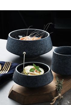 three bowls with food in them sitting on a table