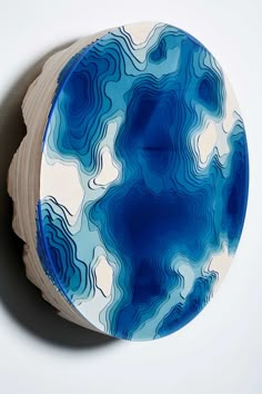 a blue and white plate sitting on top of a wooden table next to a wall