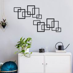 a white cabinet sitting in front of a wall mounted plant on it's side