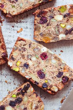 several slices of fruit and nut bread on a cutting board