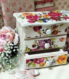 two drawers with flowers painted on them next to a bouquet of flowers and a teddy bear