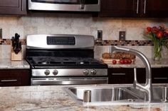 a stainless steel stove top oven sitting next to a sink and microwave in a kitchen