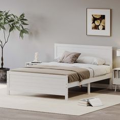 a white bed sitting in a bedroom on top of a wooden floor next to a lamp