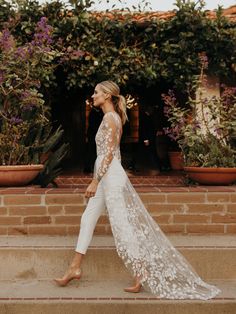 a woman in white is walking down some steps