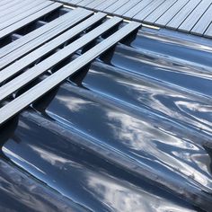 the roof of a car is covered in shiny blue tints and wood planks