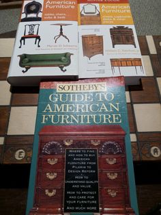 two books sitting on top of each other in front of a wooden table with chairs