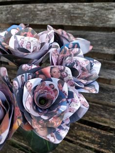 a bouquet of paper flowers sitting on top of a wooden bench