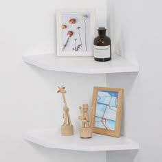 two white shelves with pictures and figurines on them, next to a framed photo