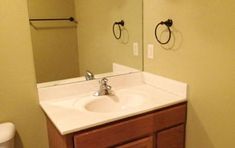 a white sink sitting under a bathroom mirror