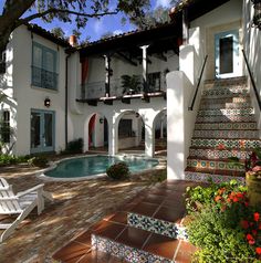 a house with a pool in the middle and stairs leading up to it's front door