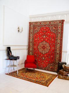 a red chair sitting in front of a rug