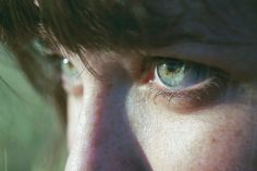 a close up of a person's face with the sun shining on their eyes