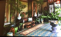 an ornate room with potted plants on the floor and large mirror in the wall