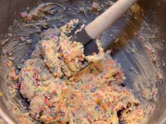 a mixing bowl filled with cake batter and sprinkles